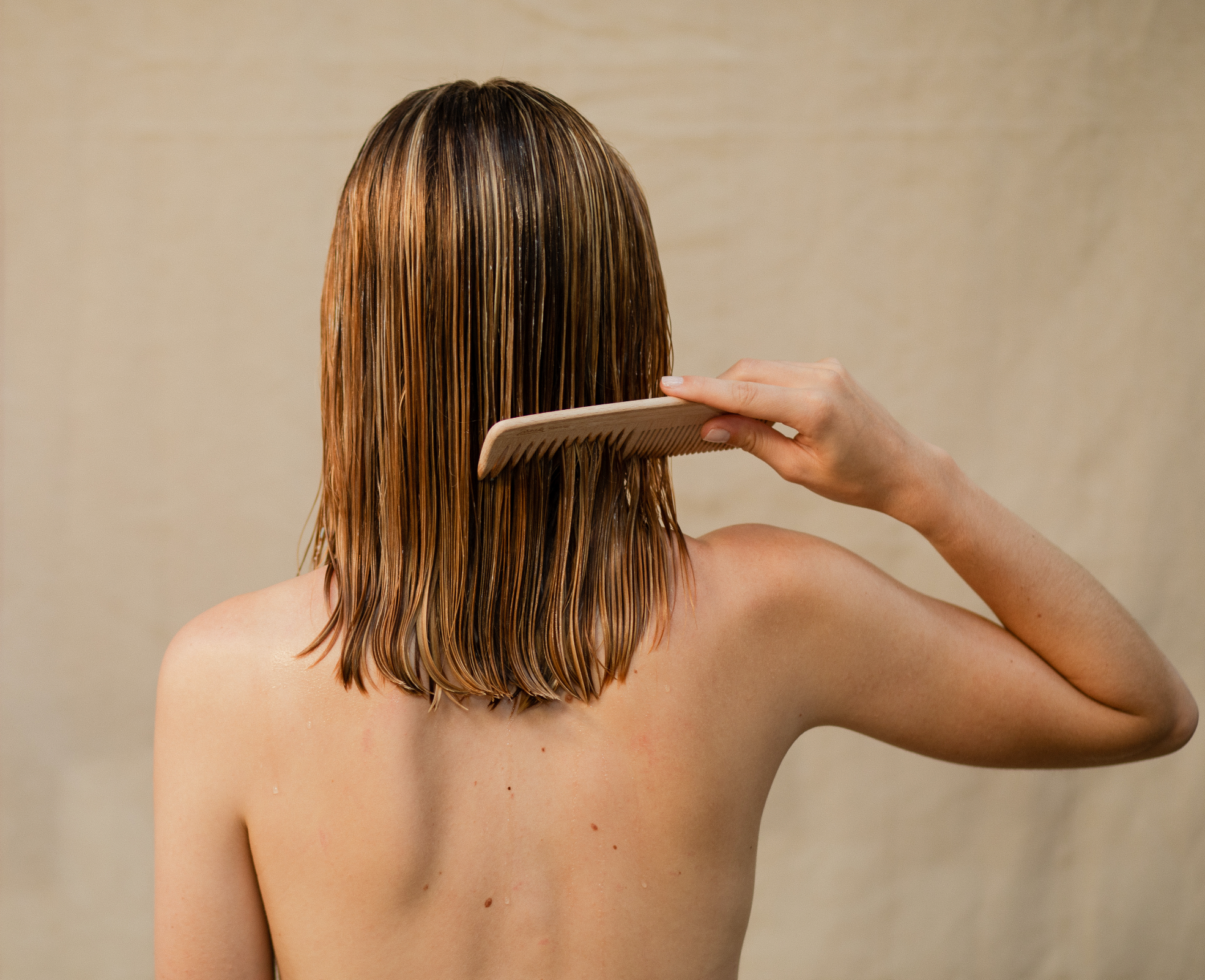 Person running brush through hair, checking for seasonal shedding